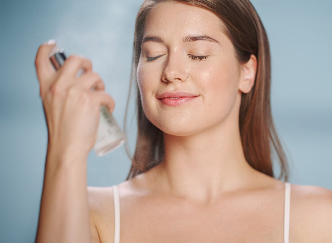 Junge Frau trägt Setting Spray auf